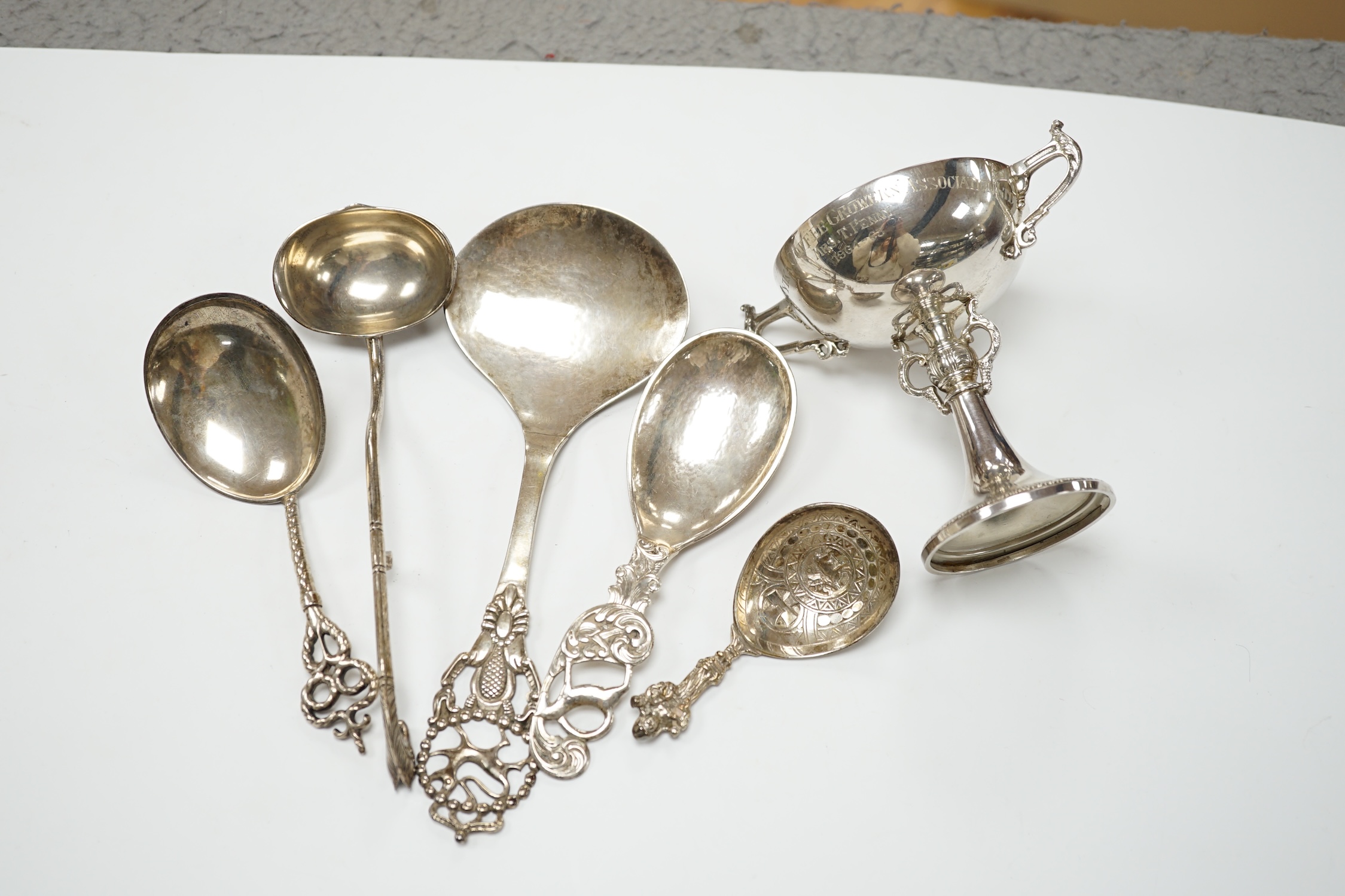 Five assorted early to mid 20th century Danish 830S spoons, largest 21.1cm, together with an Elizabeth II silver two handled presentation trophy cup with engraved inscription relating to the 'Tanganyika Coffee Growers As